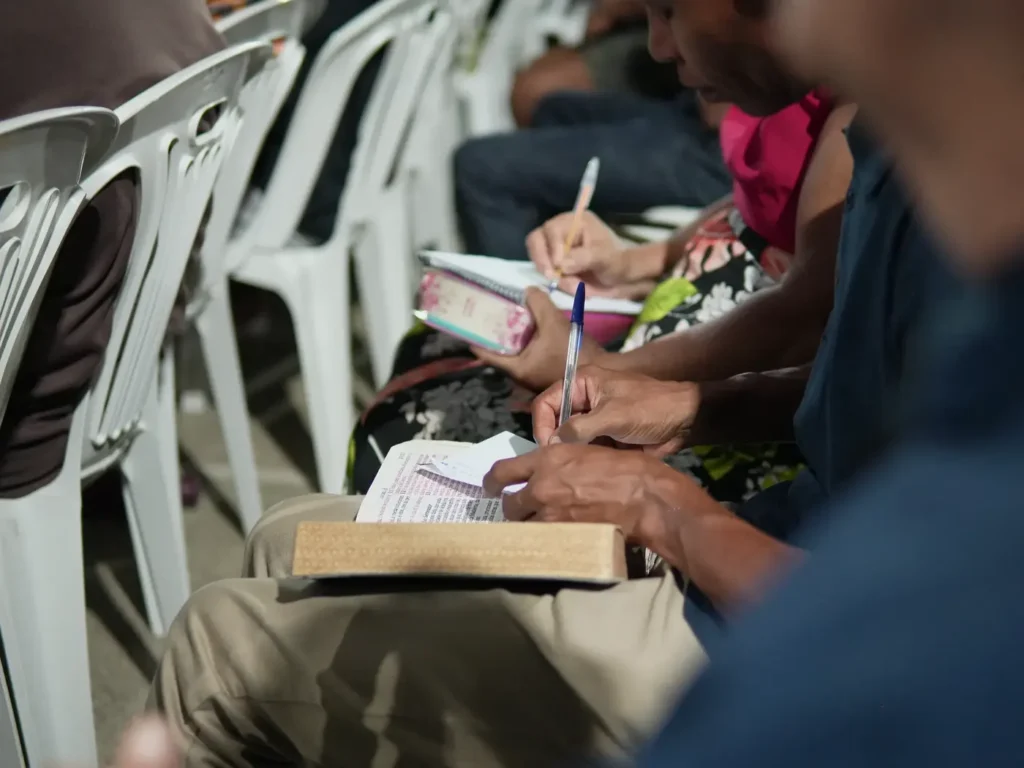 Cristãos anotando durante conferência da Missão Cristã